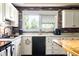 Kitchen features white cabinets, black appliances, and a brick accent wall at 3022 Cameron St, Indianapolis, IN 46203