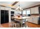 Kitchen island with granite countertop, seating, white cabinets, and black appliances at 3022 Cameron St, Indianapolis, IN 46203