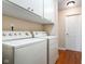 Laundry room with wood floors and front load washer and dryer with storage cabinets above at 3022 Cameron St, Indianapolis, IN 46203