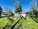 Serene backyard featuring a fire pit with seating, lush lawn, and mature trees, perfect for outdoor enjoyment at 3081 Woodridge Rd, Shelbyville, IN 46176