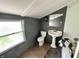 Cozy bathroom with a classic pedestal sink, tiled floor, and ample natural light at 3081 Woodridge Rd, Shelbyville, IN 46176