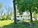 White two-story house with expansive lawn and mature trees providing shade, creating a serene outdoor setting at 3081 Woodridge Rd, Shelbyville, IN 46176