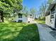 Exterior of the home featuring a pathway and a well-manicured lawn, with lush greenery all around at 3081 Woodridge Rd, Shelbyville, IN 46176