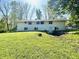 Exterior of the home featuring a well-manicured lawn with lush greenery, complemented by a bright white exterior at 3081 Woodridge Rd, Shelbyville, IN 46176