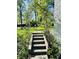 Charming front entrance featuring stone steps, a decorative archway, and well-manicured landscaping at 3081 Woodridge Rd, Shelbyville, IN 46176
