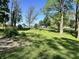 Expansive front yard featuring lush green grass, mature trees, and meticulous landscaping at 3081 Woodridge Rd, Shelbyville, IN 46176