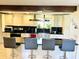 Modern kitchen island with bar stools, granite counters, and stainless steel sink with bright sunny window at 3081 Woodridge Rd, Shelbyville, IN 46176