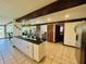 Spacious kitchen with island, granite countertops, wooden beam accents, and views to a brick walled room at 3081 Woodridge Rd, Shelbyville, IN 46176