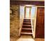 Stairway with brick wall and wooden steps leading to a door with glass panels at 3081 Woodridge Rd, Shelbyville, IN 46176