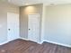 A well-lit bedroom features a neutral color scheme, two doors and laminate wood flooring at 337 N Beville Ave, Indianapolis, IN 46201