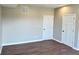 A well-lit bedroom features a neutral color scheme, two doors and laminate wood flooring at 337 N Beville Ave, Indianapolis, IN 46201