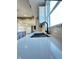 Bright kitchen features white quartz countertops, a modern black faucet and a stainless steel sink by the window at 337 N Beville Ave, Indianapolis, IN 46201