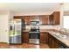 Well-lit kitchen with stainless steel refrigerator, range, microwave, dark cabinets and laminate countertops at 4033 Tahoe Dr, Indianapolis, IN 46235