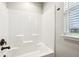 Bright bathroom features a shower-tub combination with bronze fixtures and a view from the window at 4204 Omaha Dr, Bargersville, IN 46106