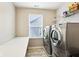 Functional laundry room with washer, dryer, folding table, and natural light from the window at 4204 Omaha Dr, Bargersville, IN 46106