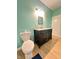 Bathroom with a toilet, vanity with marble countertop, and a dark cabinet underneath at 424 S Parker Ave, Indianapolis, IN 46201