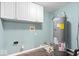 The laundry room features overhead storage cabinets, tile flooring, and a hot water heater at 4316 Village Trace Dr, Indianapolis, IN 46254