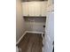 Functional laundry room with overhead cabinets and wood-look flooring at 4336 Bittersweet Ln, Greenwood, IN 46142