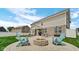 Spacious backyard patio featuring a fire pit, outdoor seating, and lush green lawn at 4763 W Tradwell Dr, New Palestine, IN 46163