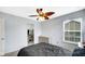 This bedroom showcases a walk-in closet, soft gray walls, neutral carpet, and a modern ceiling fan at 4763 W Tradwell Dr, New Palestine, IN 46163