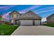 Two-story home featuring a two-car garage, neutral siding, brick accents and well-maintained lawn at 4763 W Tradwell Dr, New Palestine, IN 46163