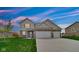 Charming two-story home featuring a well-manicured lawn, brick accents, and an attached two-car garage at 4763 W Tradwell Dr, New Palestine, IN 46163