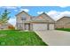 Charming two-story home featuring a well-manicured lawn, brick accents, and an attached two-car garage at 4763 W Tradwell Dr, New Palestine, IN 46163