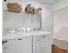 Bright laundry room featuring a modern washer and dryer with storage shelf at 4763 W Tradwell Dr, New Palestine, IN 46163