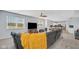 Open-concept living room, with a large sectional couch, carpeted floors, and many windows at 4763 W Tradwell Dr, New Palestine, IN 46163