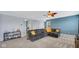 Spacious living room with a comfortable couch, modern ceiling fan, and a pop of color on the wall at 4763 W Tradwell Dr, New Palestine, IN 46163