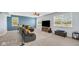 Comfortable living room featuring a large television, couch, neutral carpet, and bright windows at 4763 W Tradwell Dr, New Palestine, IN 46163