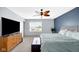 Comfortable main bedroom with ceiling fan, large window, and modern dresser at 4763 W Tradwell Dr, New Palestine, IN 46163