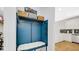 Mudroom with bench seating, storage baskets, and hooks adjacent to a kitchen with white cabinets at 4763 W Tradwell Dr, New Palestine, IN 46163