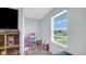 Bright playroom with natural light, showcasing a dollhouse and ample space for creativity at 4763 W Tradwell Dr, New Palestine, IN 46163