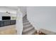 Carpeted staircase leading to the upper level with white banister, near the living room at 4763 W Tradwell Dr, New Palestine, IN 46163