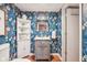 Charming bathroom with designer floral wallpaper, gray vanity, and decorative mirror at 5034 N Capitol Ave, Indianapolis, IN 46208