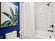 Bathroom with stylish white subway tile, navy blue accent wall, and large modern art print of banana leaves at 5034 N Capitol Ave, Indianapolis, IN 46208