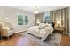 Cozy bedroom with natural light, hardwood floors, a plush bed, and neutral decor at 5034 N Capitol Ave, Indianapolis, IN 46208