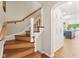 Wooden staircase with white railings leading to the upper level, adjacent to built-in storage and kitchen view at 5034 N Capitol Ave, Indianapolis, IN 46208