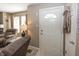 Warm entryway featuring a white front door with decorative window, leading into the carpeted living area at 540 Hanley St, Plainfield, IN 46168