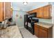 Well-lit kitchen featuring wooden cabinetry, light countertops, and essential black appliances at 540 Hanley St, Plainfield, IN 46168