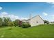 Well-maintained backyard with green lawn, mature trees, and a view of the deck and house, great for outdoor activities at 542 Hadleigh Ct, Westfield, IN 46074