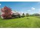 Beautiful backyard with green grass, mature trees, and serene pond view at 542 Hadleigh Ct, Westfield, IN 46074