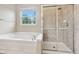 Bright bathroom featuring a soaking tub and glass-enclosed shower at 542 Hadleigh Ct, Westfield, IN 46074