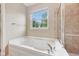 Main bath featuring a soaking tub, a window, and tiled shower at 542 Hadleigh Ct, Westfield, IN 46074
