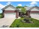Charming exterior view showcasing an attached garage, brick facade, garden and well-kept lawn at 575 Dylan Dr, Avon, IN 46123