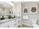 Bathroom featuring double sinks with granite countertops, white cabinets with black hardware, and decorative wall art at 583 Dalton Way, Avon, IN 46123