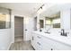 Modern bathroom with a double sink vanity, white cabinets, black hardware, and an open door to the walk-in closet at 583 Dalton Way, Avon, IN 46123