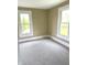 This bedroom features neutral walls, carpeted floor, and two large windows with white trim, offering plenty of natural light at 660 N 700 E, Whitestown, IN 46075