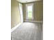 Neutral bedroom with a gray carpet and a window showing greenery outside at 660 N 700 E, Whitestown, IN 46075